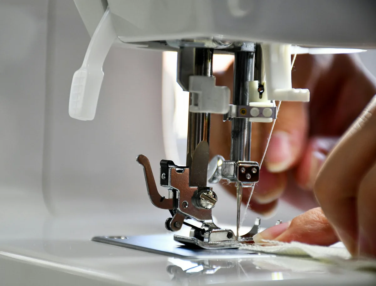 Travail minutieux de couture, le tissu guidé à la main